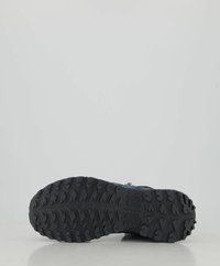 Suola di scarpa da hiking nera e robusta con un motivo testurizzato per la trazione, caratterizzata da profonde incisioni e un design angolato per una migliore aderenza.