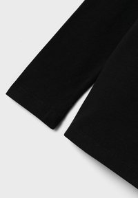 Maglietta a maniche lunghe nera in morbido cotone, con orlo arrotondato e polsini cuciti, caratterizzata da una texture liscia e un design minimalista.