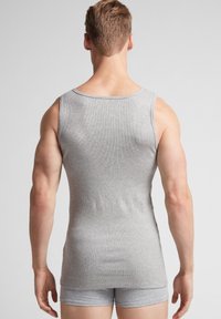 Top de tirantes gris con un escote redondo, diseño ajustado y corte sin mangas, combinado con pantalones cortos gray a juego.