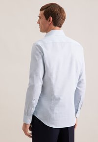 Hellblau gemustertes Hemd mit feinem geometrischem Design, langen Ärmeln und einer Rückenfalte für Komfort. Knopfmanschetten und ein spitzer Kragen.