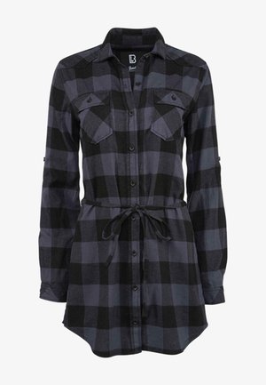 Svart og grå rutete skjorte med lange ermer, knappestolpe, to brystlommer og snøring i livet. Laget av et mykt stoff med en avslappet passform.