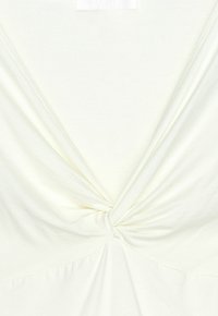 Hvid bluse med V-halsdesign og twist-detalje i midten foran samt blød, draperet stofstruktur.