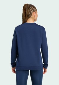 Felpa blu navy con maniche lunghe, design a girocollo, texture liscia, con un dettaglio del logo sulla manica sinistra.