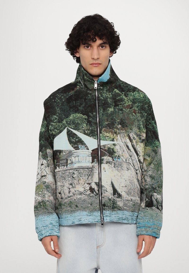 Fleece jacket with a high collar, featuring a landscape print in green and blue, zip closure, and loose-fit sleeves.