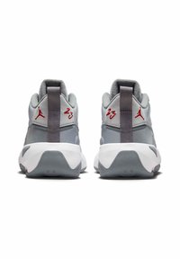 Para szaro-białych sportowych butów z czerwonym logo Jumpman i numerem 23 z tyłu, widzianych od strony tylnej.