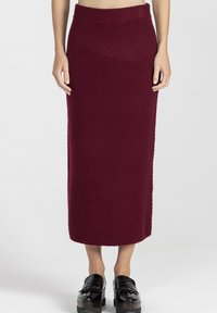 Burgundowa spódnica midi z prążkowanego dzianiny z szerokim elastycznym pasem. Połączona z czarnymi butami na platformie z frędzlami.