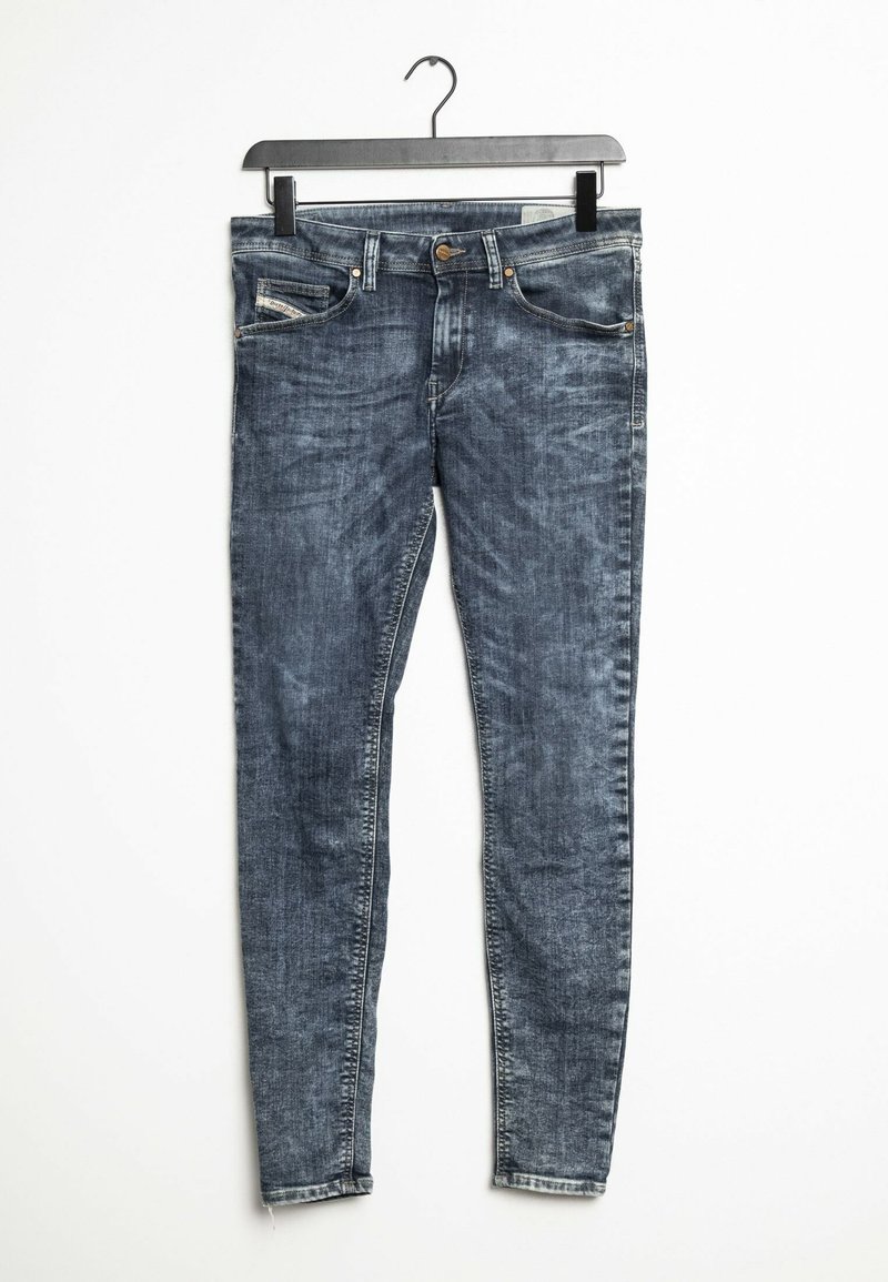 Vaqueros ajustados de denim azul oscuro, con un lavado desgastado, cinco bolsillos y cierre de botón con cremallera metálica.