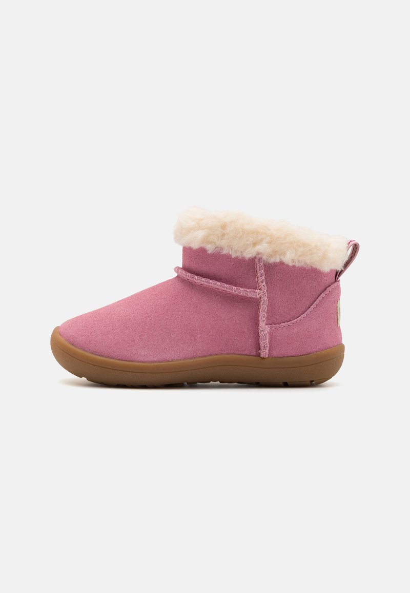 Bottes courtes roses en matériau doux et texturé, avec un col en fausse fourrure crème. Comprend une semelle en caoutchouc flexible et une boucle à l'arrière.