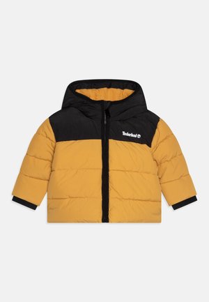 Veste rembourrée pour enfant avec capuche, corps jaune, épaules noires, fermeture éclair noire et logo Timberland sur la poitrine.