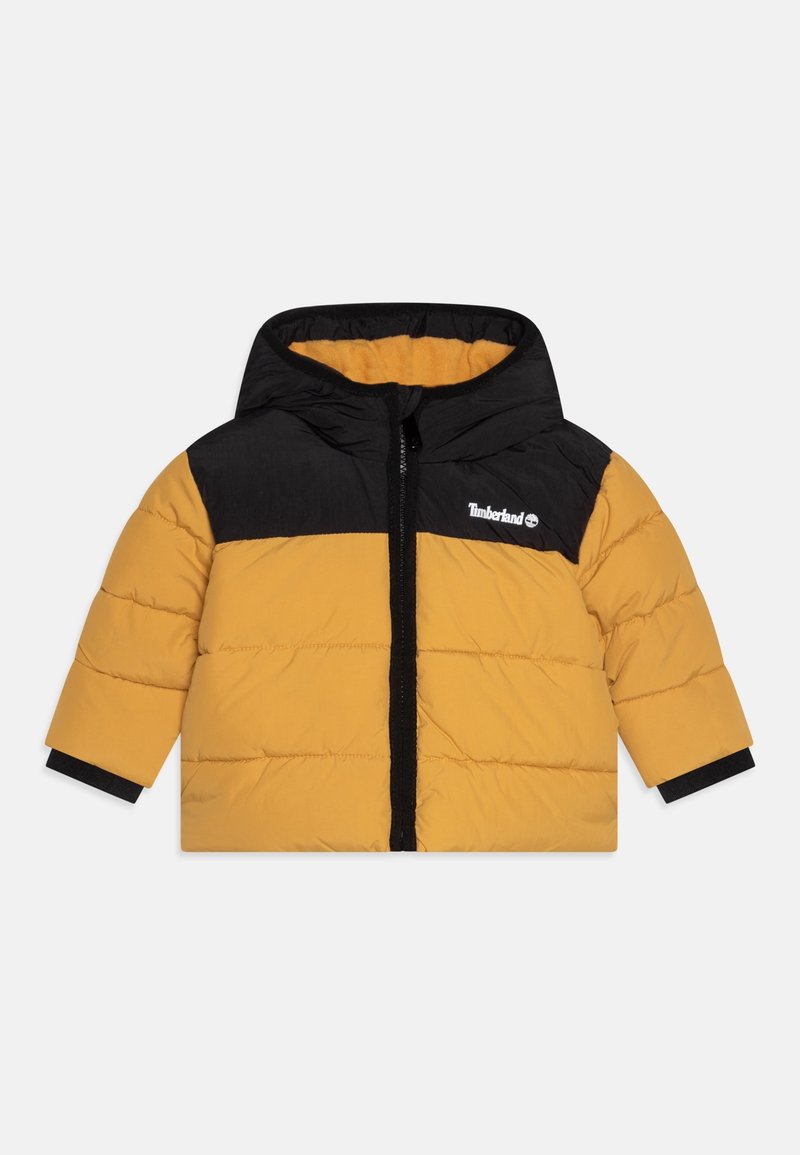 Veste rembourrée pour enfant avec capuche, corps jaune, épaules noires, fermeture éclair noire et logo Timberland sur la poitrine.