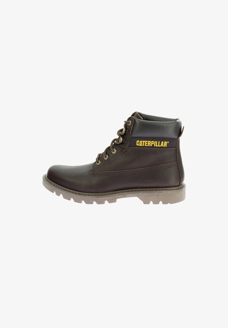 Botín de trabajo de cuero marrón con un acabado texturizado, cordones planos, suela de goma y logo amarillo de "CATERPILLAR" en el lateral. Diseño de altura hasta el tobillo.
