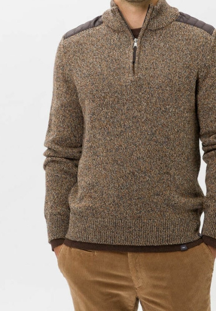 Homme portant un pull en maille marron texturé avec une fermeture éclair au quart et des renforts d'épaule sombres, associé à un pantalon en velours côtelé marron clair.