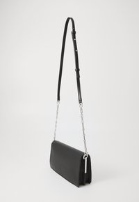 Černá kožená crossbody taška se strukturovaným tvarem, vybavená odnímatelným řetízkovým popruhem a hladkou texturou. Jednoduchý, moderní design.