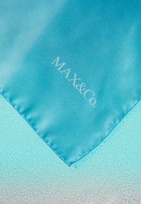 Tyrkysový saténový šátek s hladkým povrchem. Na něm se nachází stříbrné logo "MAX&Co." a gradientní pozadí s jemným leskem.