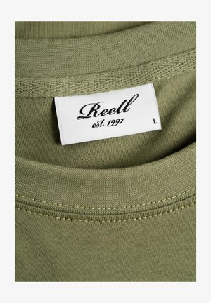 Olive green cotton t-shirt with a crew neckline. Visible label with "Reell" and "est. 1997" in black on a white background, size L.