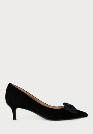 Décolleté in suede nero con punta appuntita, tacco basso e un fiocco decorativo nero sul davanti. Fodera interna liscia.