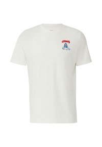 T-shirt en coton blanc avec un texte rouge "JAWS" et un graphique de requin bleu avec des vagues sur la partie gauche de la poitrine. Manches courtes, design col rond.