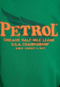 Grön tyg med orange text "PETROL" och mindre text som refererar till Chicago Half-Mile League U.S.A. Championship sedan 1973.