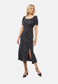 Black and grey zebra print dress with short puff sleeves, a square neckline, and a mid-length skirt featuring a side slit and fitted design.