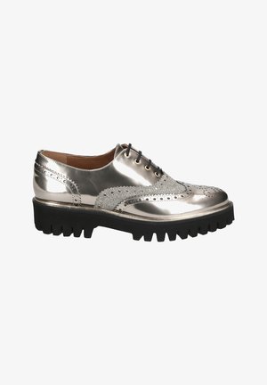Chaussure Oxford en cuir argenté brillant avec détails brogue, lacets noirs, panneaux latéraux texturés et semelle épaisse à crampons noire.