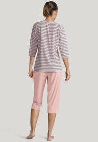 Dames loungewear set met een gestreepte top met driekwart mouwen in lichtroze en marineblauw, gecombineerd met effen roze cropped broeken.