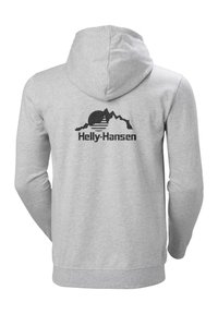 Sudadera gris con un logo negro de Helly Hansen y un gráfico de montaña en la parte posterior, con un bolsillo tipo canguro y capucha ajustable con cordón.