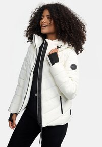 White puffer jacket with a glossy finish, black accents, zippered pockets, adjustable hood, and a quilted design. Features logo patch on sleeve.