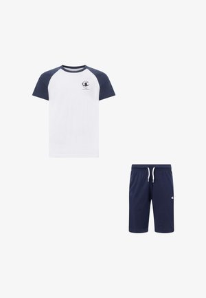 T-shirt blanc avec manches raglan bleu marine et logo sur la poitrine, associé à un short bleu marine à cordon avec petit logo sur la jambe gauche.