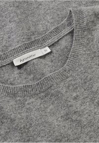 Gray knitted sweater with a crew neck, featuring a soft texture and a label reading "hessnatur 36" on the side.