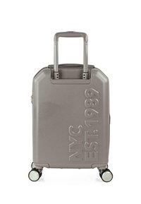 Maleta rígida gris con diseño en relieve "NYC EST. 1989", asa retráctil y cuatro ruedas con detalles plateados.