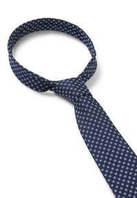 Cravate bleu marine avec un motif texturé de petits carrés blancs. Tissu lisse avec une forme classique et une finition soignée à l'extrémité étroite.