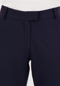 Navy broek van een gladde stof, met een aangesloten tailleband en twee voorkruiszakken. Het ontwerp is nauwkeurig en heeft een nette afwerking.
