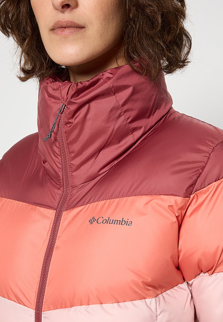 Kurtka puchowa w kolorowe bloki z wysokim kołnierzem, zapięciem na zamek, w odcieniach czerwieni i brzoskwini, o gładkiej fakturze oraz z logo na klatce piersiowej.