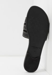 Semelle noire d’une sandale pour femme avec une semelle texturée et trois brides noires visibles de côté, taille 37, marque Vagabond Shoemakers.