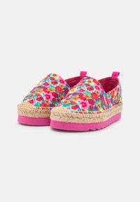 Espadrilles florales con una parte superior de tela multicolor con acentos en rosa, suela de yute y una suela de goma texturizada para mayor agarre.