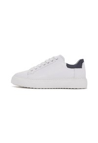 Zapatilla baja blanca con suela gruesa, parte delantera con cordones y cuello acolchado negro en el talón, mostrada de perfil sobre un fondo blanco.
