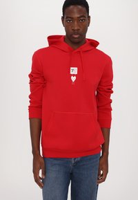 Red hoodie with a front pocket, drawstring hood, and a graphic design featuring a heart and text on the chest. Fabric appears soft.