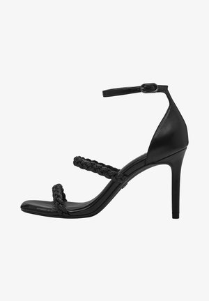 Sandalia de tacón alto negra con dos correas trenzadas y una correa en el tobillo, con un acabado de cuero suave y un diseño elegante de punta afilada.