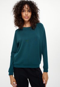 Teal sweatshirt met een relaxte pasvorm, geribbelde manchetten en een ronde hals; gemaakt van zachte stof met subtiele textuur en zijnaaddetails.