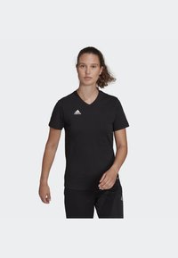 Tricou sport negru cu guler în V, confecționat dintr-un material respirabil, având logo-ul alb Adidas pe partea stângă a pieptului și mâneci scurte.