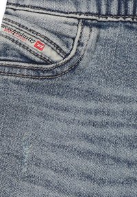 Jeans in denim blu sbiadito con un classico design a cinque tasche. Include un piccolo etichetta rossa sulla tasca anteriore e dettagli di cucitura discreti.