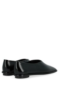 Chaussures noires en cuir à enfiler avec une finition lisse, un bout arrondi et un talon bas. Design minimaliste sans motifs ni matériaux métalliques visibles.
