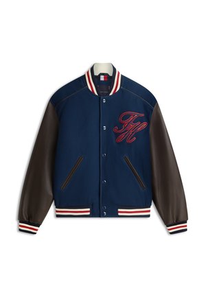 Marineblaue Collegejacke mit dunkelbraunen Ledärmeln, gestreiftem Kragen und Bündchen, Druckknöpfen, Fronttaschen und roten, aufgestickten Initialen "TH" auf der Brust.