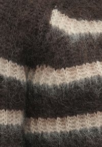 Pulover tricotat cu dungi maro închis și bej deschis, având o textură pufoasă și un detaliu distinct de cusătură cu model.