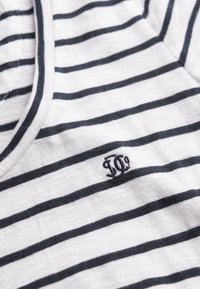 Bomuld T-shirt med marineblå vandrette striber på hvid baggrund, med et lille broderet logo i det nederste hjørne. Blød tekstur.