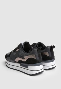 Černé a šedé sportovní boty vyrobené z jemné k ůže a syntetického materiálu, s textilním svrškem, texturovanými akcenty a bílou gumovou podrážkou.