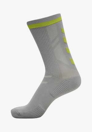 Grijze sportkous met een geribbelde textuur, voorzien van een opvallende groene streep aan de bovenkant en drie groene accenten aan de zijkant.
