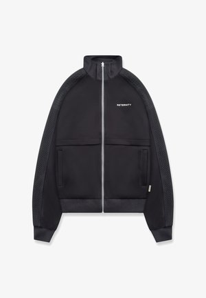 Giacca nera con cerniera, strisce testurizzate sulle maniche, colletto alto, due tasche frontali e testo "RETERNITY" sul petto sinistro.