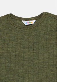 Približna snimka zelene rebraste pletene dječje majice s okruglim izrezom i dva kopčana gumba na ramenu.