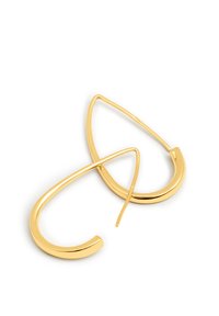Pendientes de aro en tono dorado con una forma moderna y alargada de gota. Textura suave y un diseño minimalista con una curva sutil.